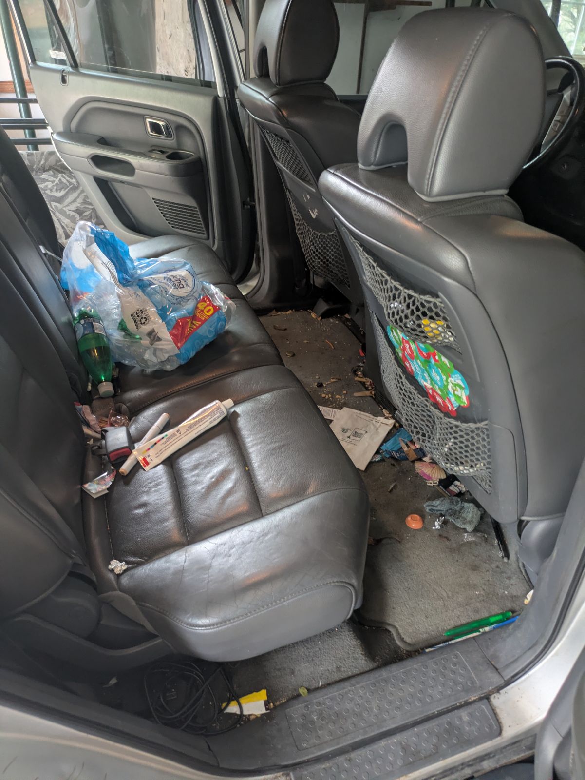 Back seat before detailing, covered in trash